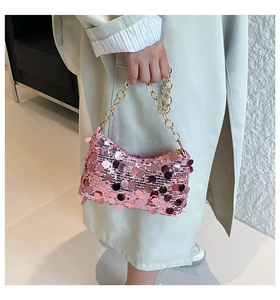Close-up of pink sequined shoulder bag with elegant gold chain strap and reflective texture