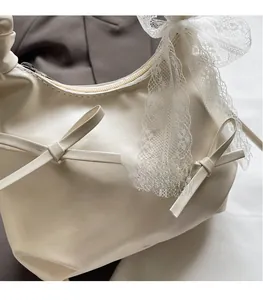 Close-up of beige bucket bag featuring bow decorations and white lace trim on the handle