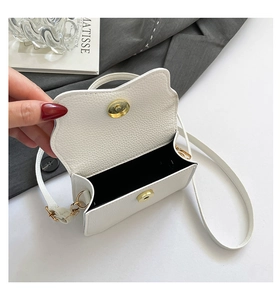 Détail du petit sac blanc en cuir grainé avec rabat courbé et fermoir magnétique doré