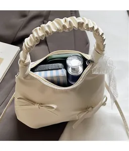 Macro view of cream bucket bag interior space with bows and pleated handle details