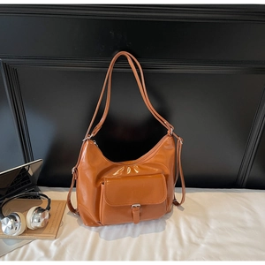 Detail of brown faux leather tote bag with front buckle pocket and adjustable straps
