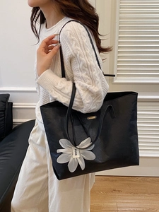 Large black tote bag with white flower charm and natural crinkle texture for women