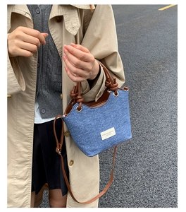 Scatto all'aperto di borsa a spalla in denim con manici in pelle marrone e etichetta