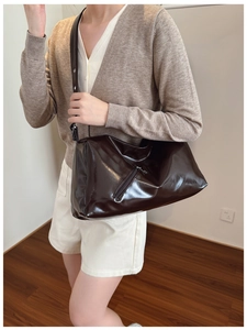 Detail of dark brown glossy tote bag showing large capacity and shiny leather texture