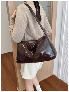 Detailed view of spacious glossy leather tote bag in dark brown with silver zipper pocket