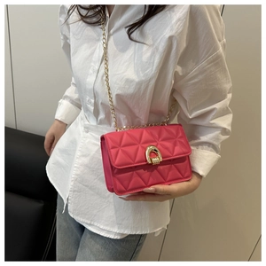 Détail du sac bandoulière matelassé magenta avec boucle dorée et bandoulière chaîne