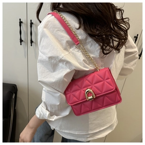 Detailansicht der magentafarbenen Steppledertasche mit goldener Kette und Schnalle