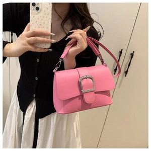 Detail showing the bright pink shoulder bag with large silver buckle in a mirror selfie