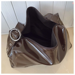 Detailed interior view of a dark brown glossy patent leather tote with silver hardware