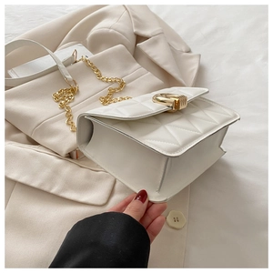 Detail der weißen Stepptasche mit goldener Metallschnalle und Rautensteppung am Gurt