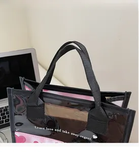 Dettaglio dei manici in nylon nero su borsa tote in PVC trasparente con stampa di cuori