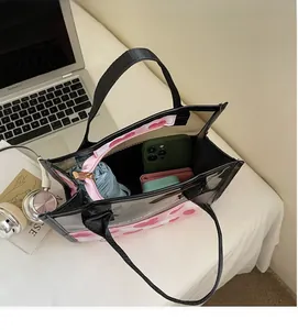 Dettaglio della borsa trasparente con interno capiente e decorazione a cuore rosa