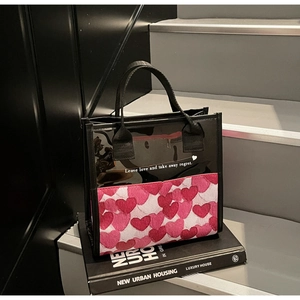 Detail of transparent heart print tote bag showing pink hearts and printed quote