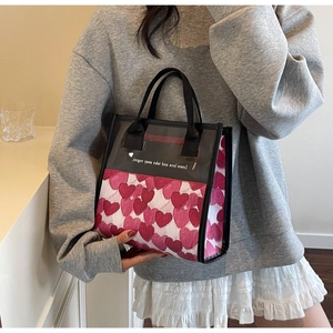 Detail of PVC waterproof makeup bag featuring pink heart patterns and fabric handle