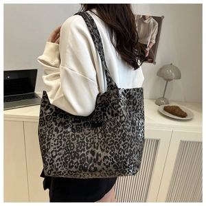 Rear view of a model wearing a leopard print canvas tote bag in a cozy home office setting
