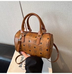 Détail d'un sac polochon marron avec motifs d'ours et ferrures en métal argenté