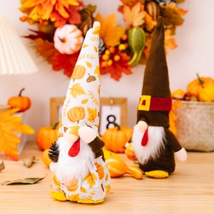 Detailaufnahme von Erntedankfest-Wichteln mit Kürbismustern und Herbst-Zapfen-Dekorationen