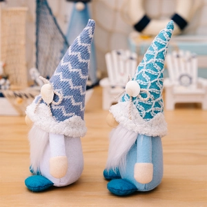 Detail of nautical summer gnomes with knitted hats and seashell decor on wooden surface
