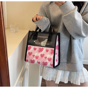 Dettaglio della borsa tote in PVC impermeabile con stampe a cuore rosa e manici neri