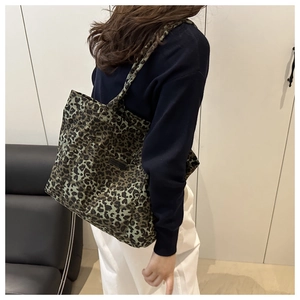 Detailed view of large leopard print tote bag on model showing size and canvas texture