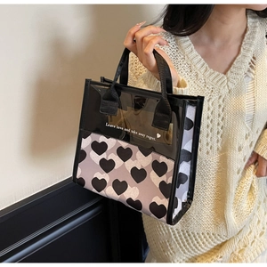 Detail of transparent PVC tote bag with black heart prints and artistic typography