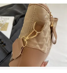 Close-up of polished gold hardware and quilted beige leather on this stylish bucket bag