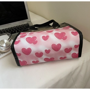Detail view of heart print tote bag on desk with laptop and lifestyle accessories