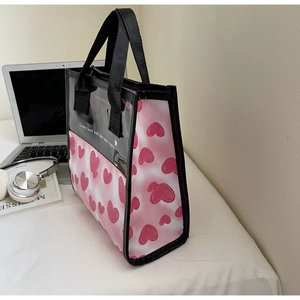 Detailed view of pink heart pattern tote bag with transparent top and black handles