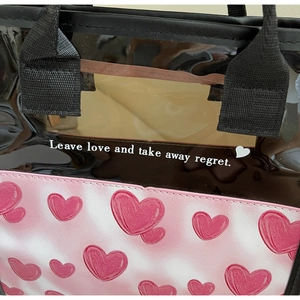 Detail of pink heart print leather and translucent PVC material on a large tote bag