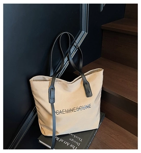 Gros plan sur un grand sac cabas en toile beige avec imprimé de lettres noires