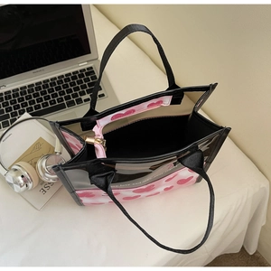 Detailed view of PVC heart print tote bag with a pink interior zipper pouch for privacy