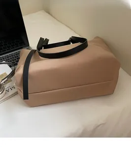 Vue détaillée du sac cabas kaki avec anses en cuir noir et texture en cuir synthétique épurée