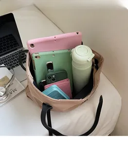 Vue intérieure montrant la grande capacité du sac fourre-tout beige avec accessoires