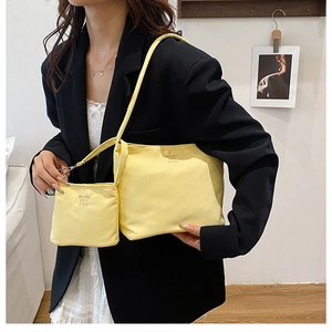 Detail of yellow nylon tote bag set with small hanging pouch and brand embossing