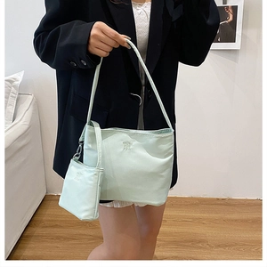 Close-up of mint green nylon tote set with matching pouch and embossed logo detail