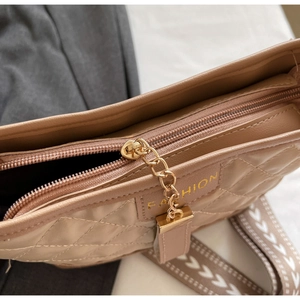 Detail of beige quilted shoulder bag featuring zipper closure and fashion gold chain