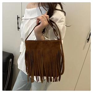 Close-up of brown suede tassel crossbody bag showing long fringe details and strap