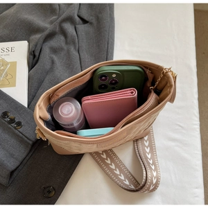 Spacious beige quilted handbag showing phone, wallet and lotion inside a large compartment