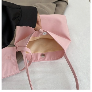 Close-up detail of a pink nylon tote bag showing the internal magnetic snap closure