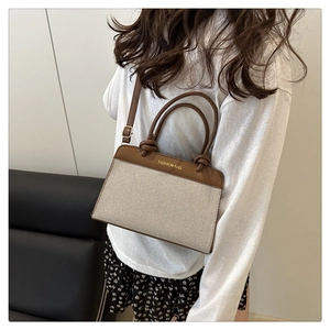 Detail of vintage patchwork crossbody bag with brown leather trim and canvas texture