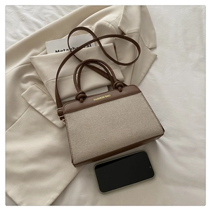 Détail du sac rétro en toile beige et cuir marron avec accessoires de mode élégants