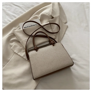 Détail du sac à main en tissu tissé et cuir marron avec anses nouées et fine bandoulière