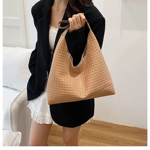 Detail of the high-capacity khaki woven hobo bag showing the intricate leather texture on shoulder