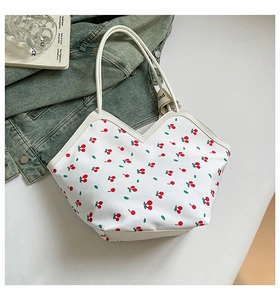 Detail of white tote bag with red cherry pattern and unique V-cut edge design