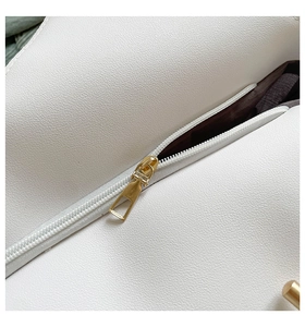 Close-up of white lychee pattern leather with a premium gold zipper on a tote bag