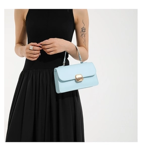 Detail of light blue vintage oil wax leather handbag with golden metal push-lock closure