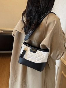 Chic black and white quilted crossbody bag with golden fashion tag and heart print strap
