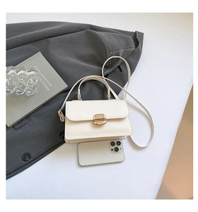 Mini cream crossbody bag with gold hardware shown next to a smartphone for size reference