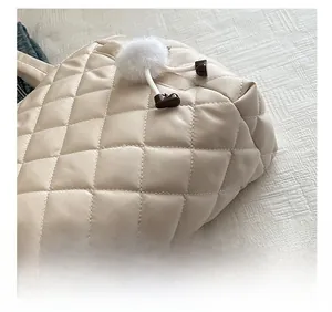 Detailed shot of quilted beige tote bag showing precision stitching and plush charm