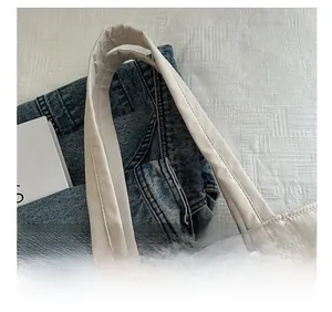 Close-up of the comfortable wide shoulder strap on a quilted beige underarm tote bag